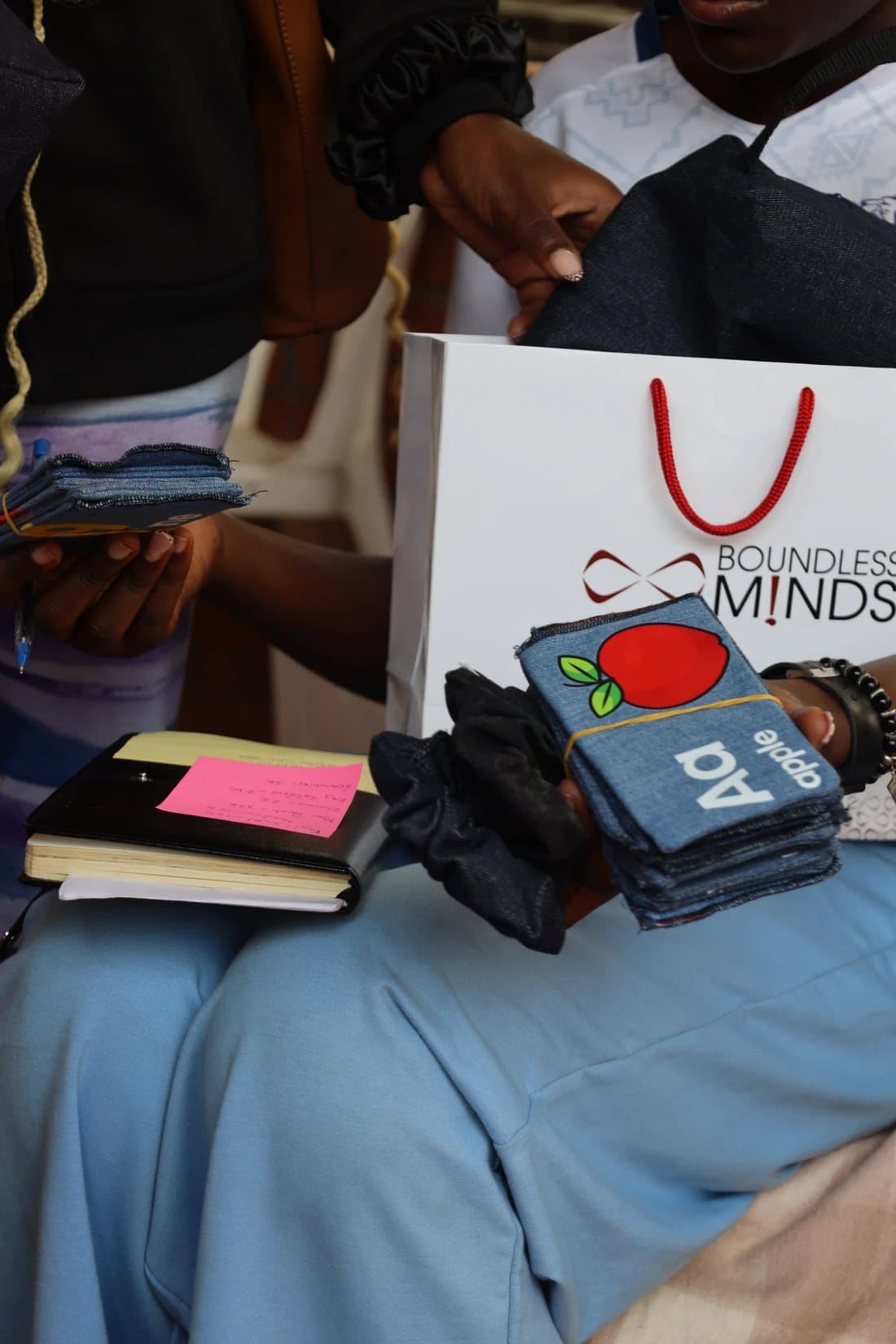 Corps members handling denim alphabet cards and a branded Boundless bag